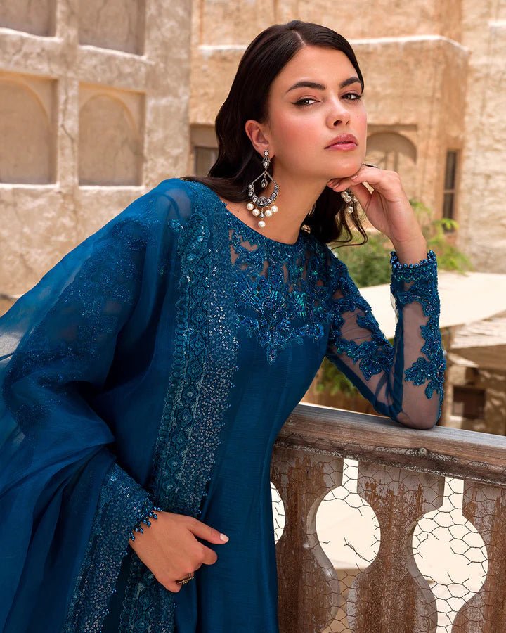 Model wearing a rich blue Nuzar dress by Faiza Saqlain, showcasing exquisite Pakistani fashion available online in the UK.