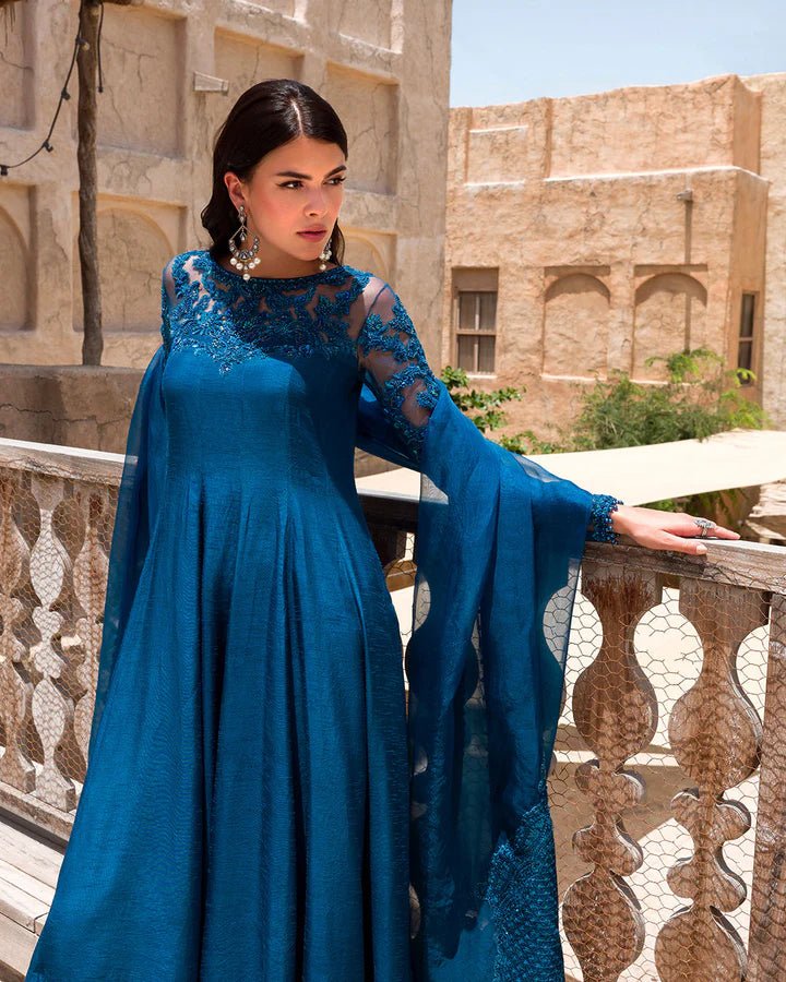 Model wearing a rich blue Nuzar dress by Faiza Saqlain, showcasing exquisite Pakistani fashion available online in the UK.