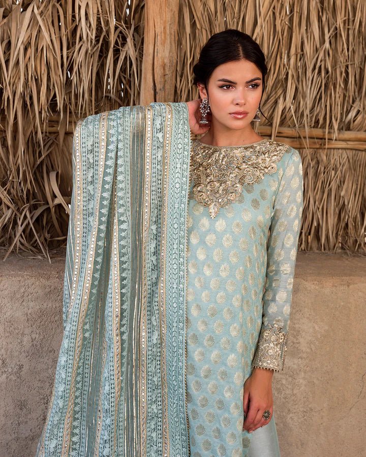 Model wearing a serene aqua Saahi dress by Faiza Saqlain, representing stylish Pakistani attire online in the UK.