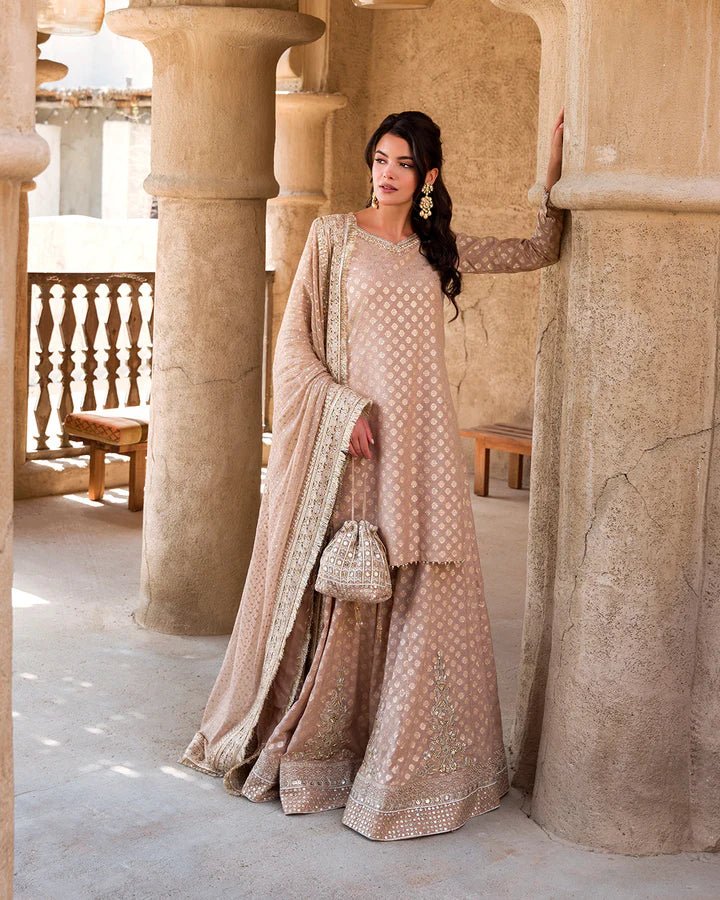 Model wearing a subtle gold Zaain dress by Faiza Saqlain, showcasing elegant Pakistani fashion available online in the UK.