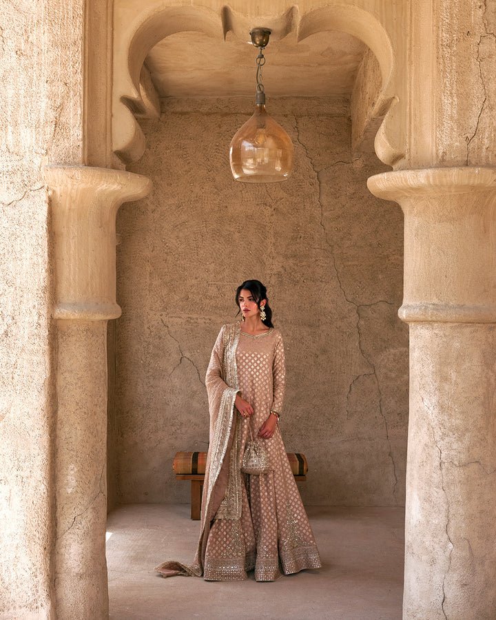 Model wearing a subtle gold Zaain dress by Faiza Saqlain, showcasing elegant Pakistani fashion available online in the UK.