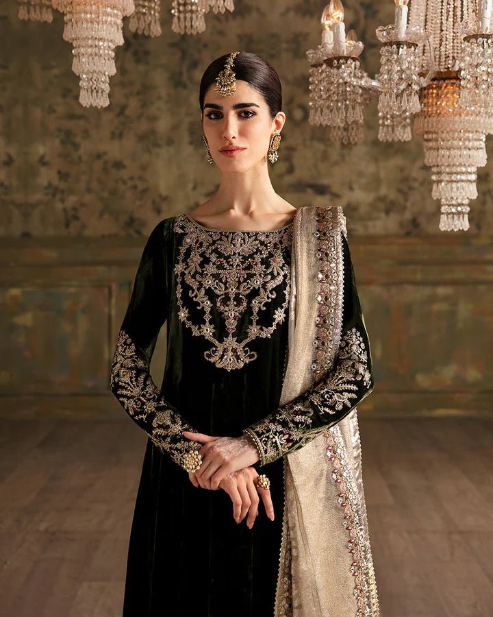 Model wearing a dark green Tissa dress with detailed gold embroidery from Faiza Saqlain's Luxe Formals Manaar Nov '23 collection. Pakistani clothes online in UK.