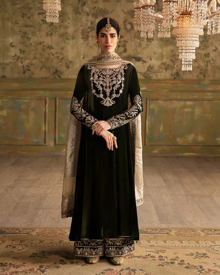 Model wearing a dark green Tissa dress with detailed gold embroidery from Faiza Saqlain's Luxe Formals Manaar Nov '23 collection. Pakistani clothes online in UK.