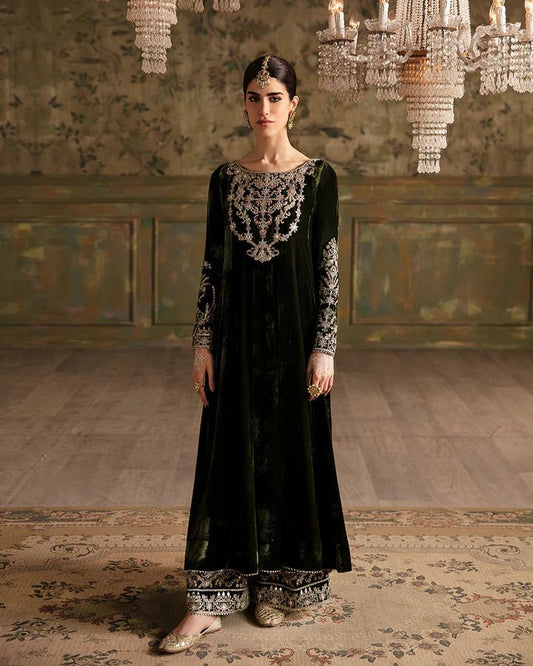 Model wearing a dark green Tissa dress with detailed gold embroidery from Faiza Saqlain's Luxe Formals Manaar Nov '23 collection. Pakistani clothes online in UK.