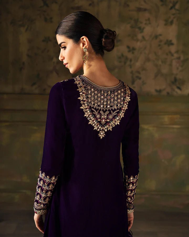 Model wearing a deep purple Elayha dress with intricate gold embroidery from Faiza Saqlain's Luxe Formals Manaar Nov '23 collection. Pakistani clothes online in UK.