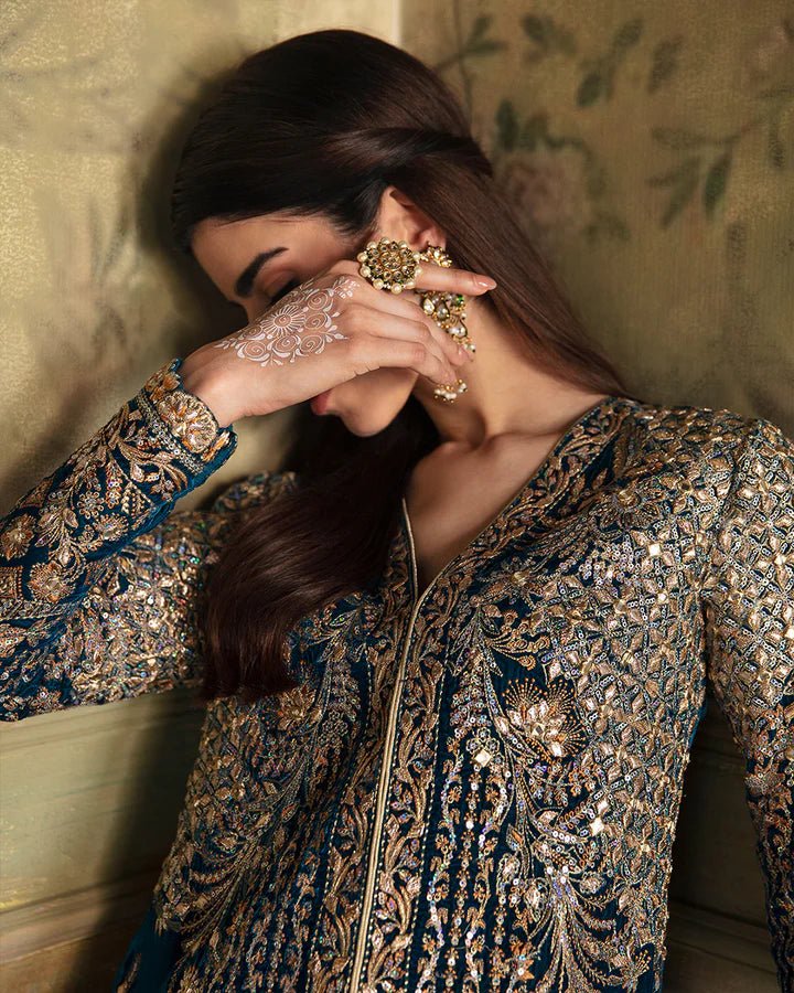 Model wearing a blue Haanie dress with intricate gold embroidery from Faiza Saqlain's Luxe Formals Manaar Nov '23 collection. Pakistani clothes online in UK.