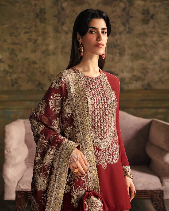 Model wearing a maroon Negar dress with intricate gold embroidery from Faiza Saqlain's Luxe Formals Manaar Nov '23 collection. Pakistani clothes online in UK.