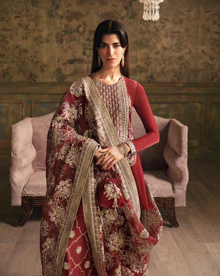 Model wearing a maroon Negar dress with intricate gold embroidery from Faiza Saqlain's Luxe Formals Manaar Nov '23 collection. Pakistani clothes online in UK.