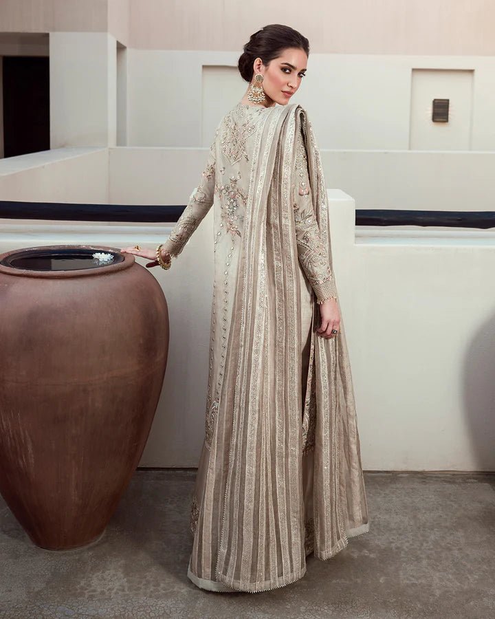 Model wearing a beige Arsh dress with intricate embroidery from Faiza Saqlain's Aleira Evening Edit '24 collection. Pakistani clothes online in UK.