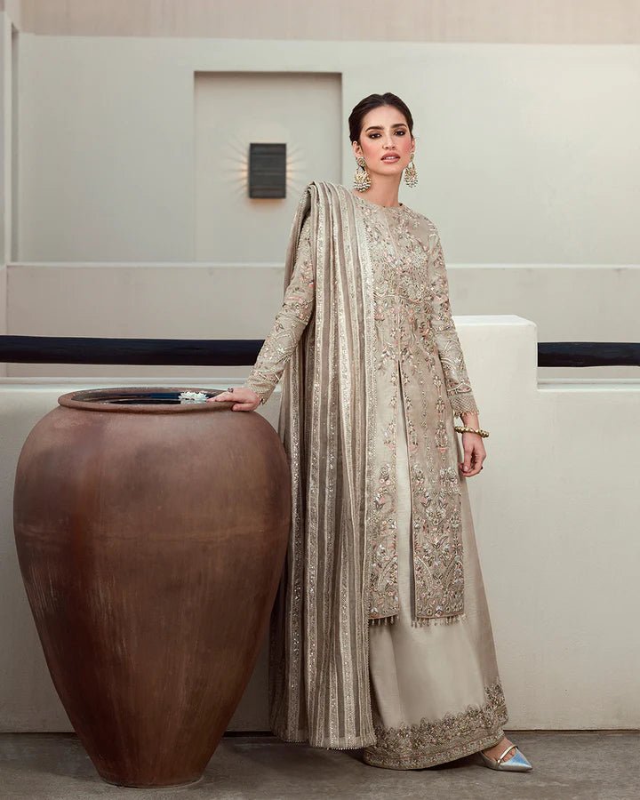 Model wearing a beige Arsh dress with intricate embroidery from Faiza Saqlain's Aleira Evening Edit '24 collection. Pakistani clothes online in UK.