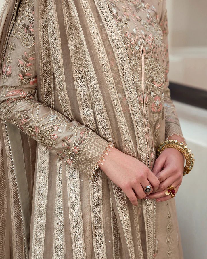 Model wearing a beige Arsh dress with intricate embroidery from Faiza Saqlain's Aleira Evening Edit '24 collection. Pakistani clothes online in UK.