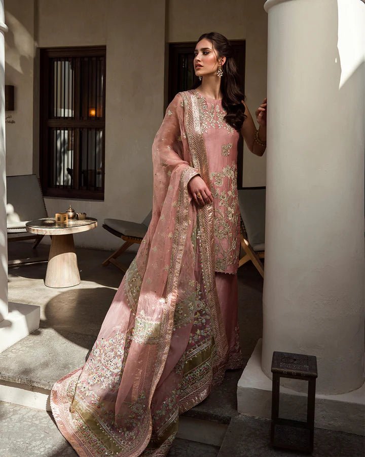 Model wearing a peach Marissa dress adorned with intricate gold embroidery from Faiza Saqlain's Luxe Formals Noor e Chashm collection. Pakistani clothes online in UK.