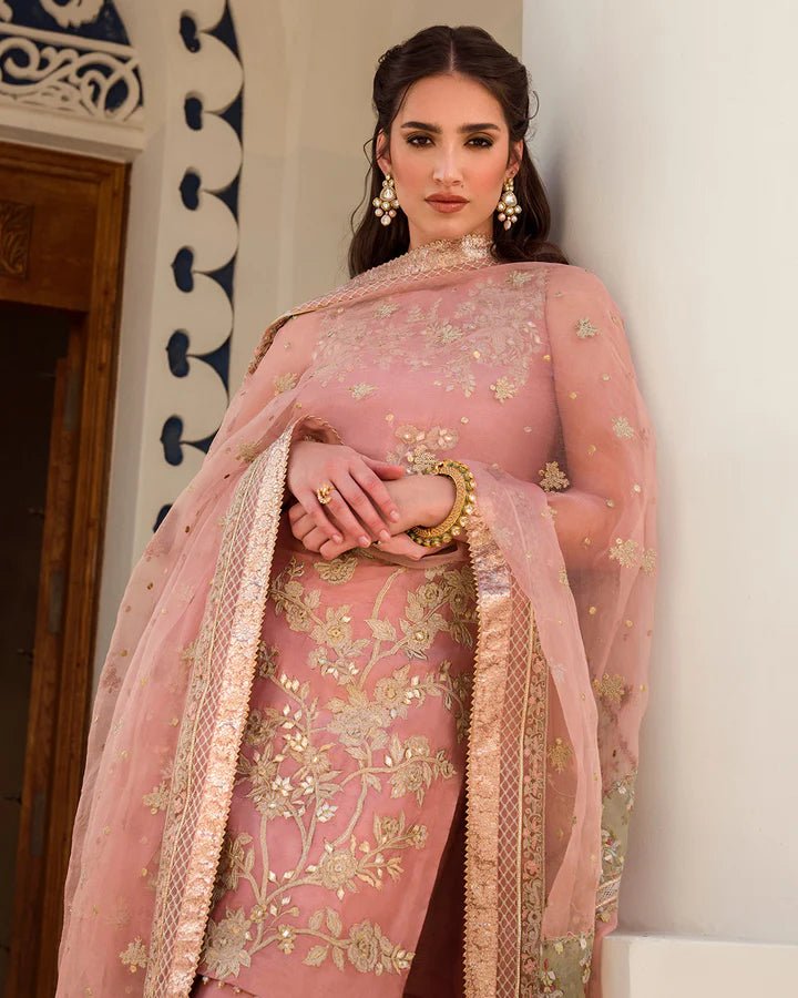 Model wearing a peach Marissa dress adorned with intricate gold embroidery from Faiza Saqlain's Luxe Formals Noor e Chashm collection. Pakistani clothes online in UK.