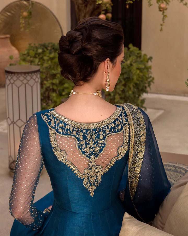 Model wearing a royal blue Risma dress embellished with intricate silver motifs from Faiza Saqlain's Luxe Formals Noor e Chashm collection. Pakistani clothes online in UK.