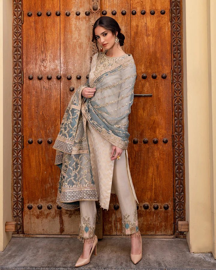 Model wearing a pale blue Talia dress from Faiza Saqlain's Luxe Formals Noor e Chashm collection, showcasing elegant Pakistani clothes online in the UK.