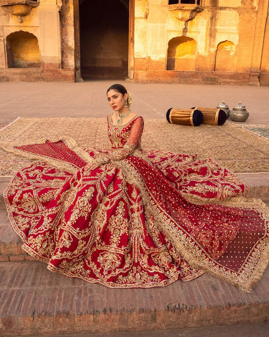 Model wearing a red Arusa bridal dress from Faiza Saqlain, intricately embroidered with gold detailing. Perfect for luxury bridal wear, available online in the UK.