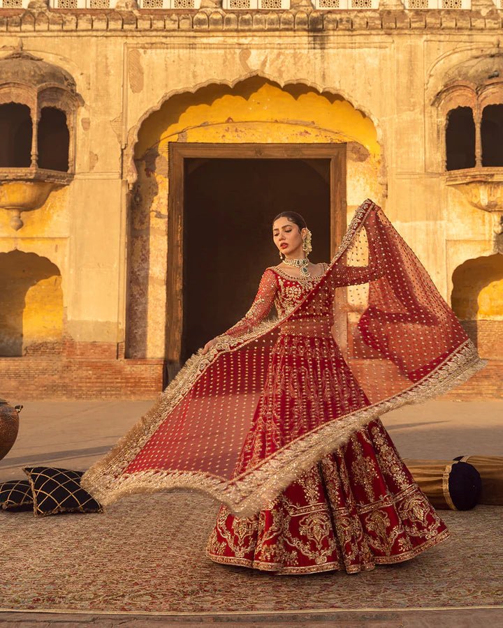 Model wearing a red Arusa bridal dress from Faiza Saqlain, intricately embroidered with gold detailing. Perfect for luxury bridal wear, available online in the UK.