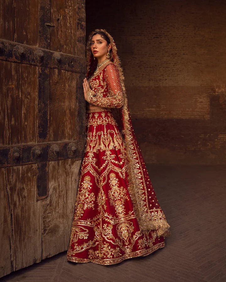 Model wearing a red Arusa bridal dress from Faiza Saqlain, intricately embroidered with gold detailing. Perfect for luxury bridal wear, available online in the UK.