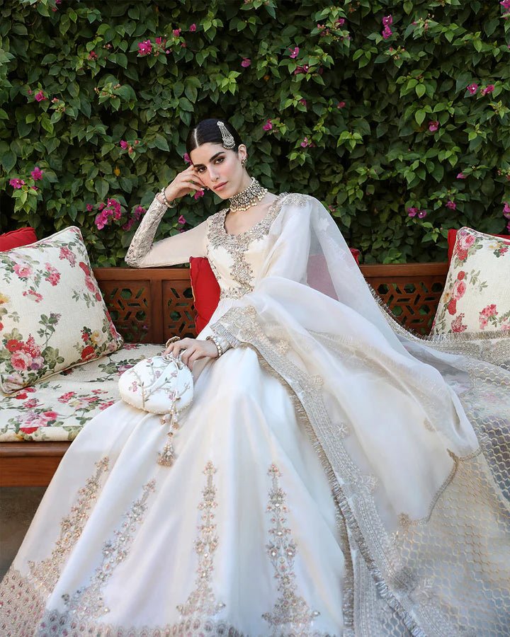 Model wearing an ivory Ailia dress from Faiza Saqlain's Mehermah Luxe Formals '24 collection. Pakistani clothes online in UK, wedding clothes.