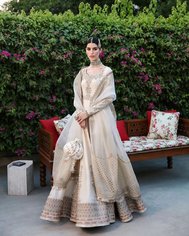 Model wearing an ivory Ailia dress from Faiza Saqlain's Mehermah Luxe Formals '24 collection. Pakistani clothes online in UK, wedding clothes.