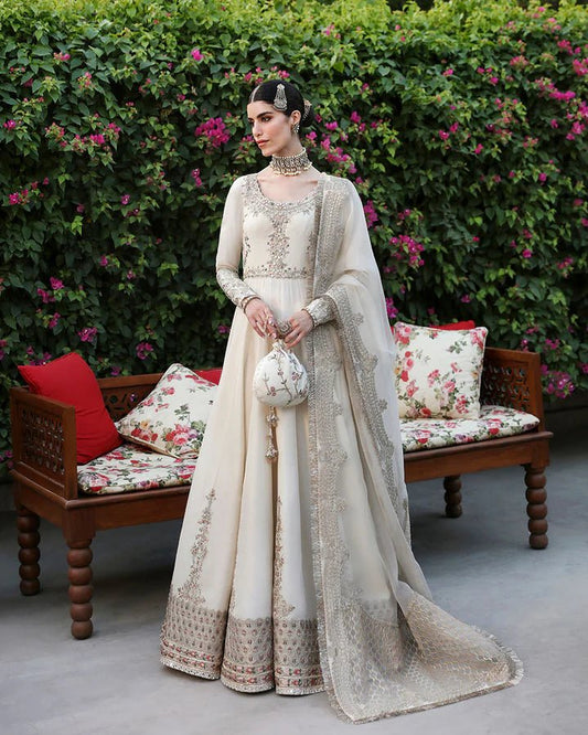 Model wearing an ivory Ailia dress from Faiza Saqlain's Mehermah Luxe Formals '24 collection. Pakistani clothes online in UK, wedding clothes.