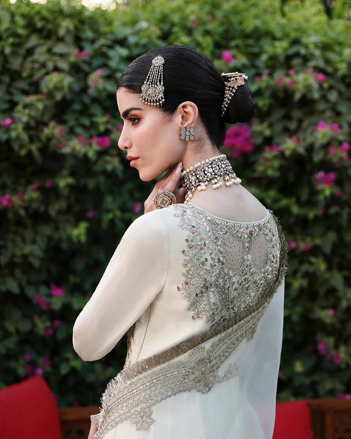 Model wearing an ivory Ailia dress from Faiza Saqlain's Mehermah Luxe Formals '24 collection. Pakistani clothes online in UK, wedding clothes.