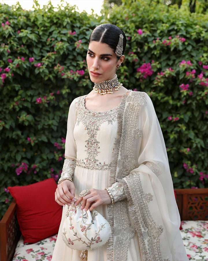 Model wearing an ivory Ailia dress from Faiza Saqlain's Mehermah Luxe Formals '24 collection. Pakistani clothes online in UK, wedding clothes.