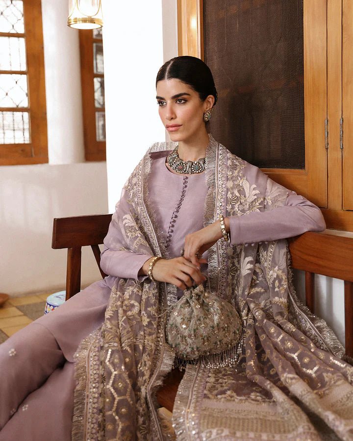 Model wearing a maroon dress with intricate silver embroidery from Faiza Saqlain's Mehermah Luxe Formals '24 collection, perfect for weddings.