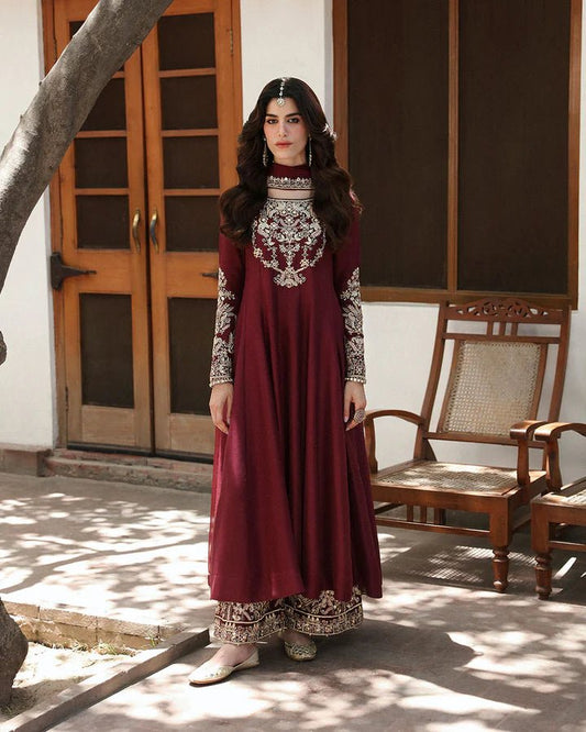 Model wearing a maroon dress with intricate gold embroidery, from Faiza Saqlain's Mehermah Luxe Formals '24 collection, highlighting Pakistani clothes online in UK and wedding clothes.