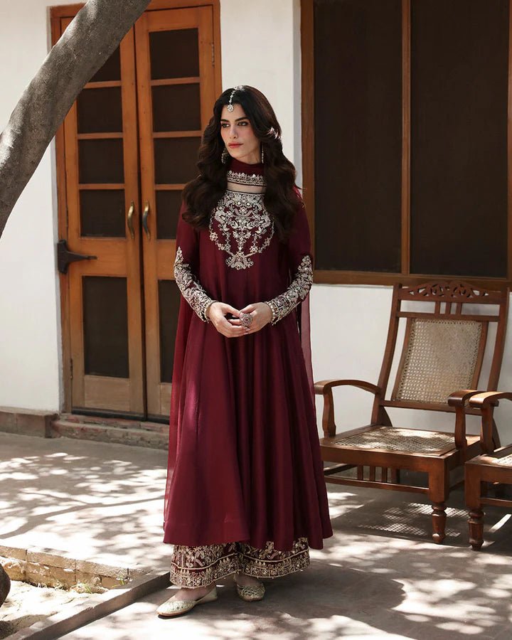 Model wearing a maroon dress with intricate gold embroidery, from Faiza Saqlain's Mehermah Luxe Formals '24 collection, highlighting Pakistani clothes online in UK and wedding clothes.