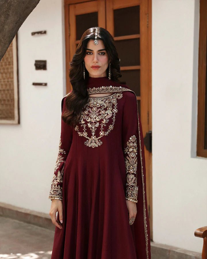 Model wearing a maroon dress with intricate gold embroidery, from Faiza Saqlain's Mehermah Luxe Formals '24 collection, highlighting Pakistani clothes online in UK and wedding clothes.