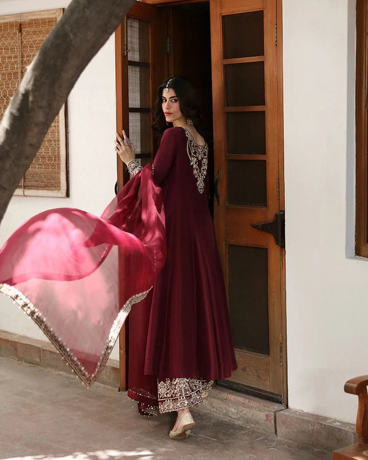 Model wearing a maroon dress with intricate gold embroidery, from Faiza Saqlain's Mehermah Luxe Formals '24 collection, highlighting Pakistani clothes online in UK and wedding clothes.