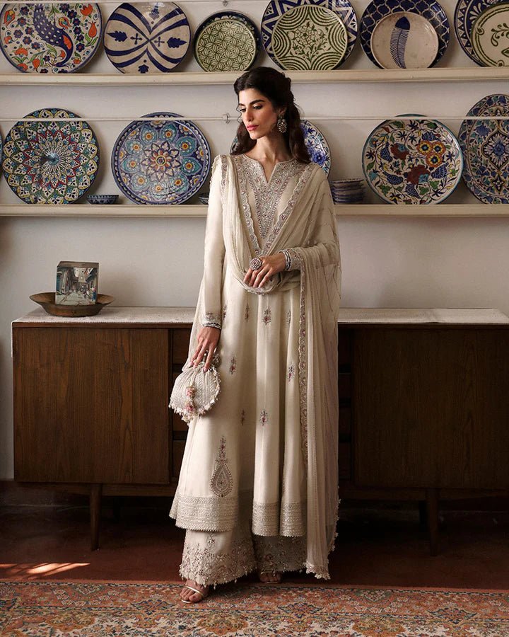 Model wearing Sabina cream dress from Faiza Saqlain, showcasing intricate embroidery and luxurious detailing, ideal for wedding attire. Pakistani clothes online in UK.