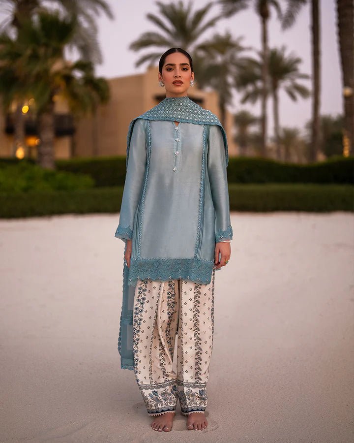 Model wearing the Venilia dress from Faiza Saqlain Zurina Luxe Silk Edit '24 in soft blue with ivory trousers, detailed with intricate embroidery, perfect for Pakistani designer Eid dresses in the UK.