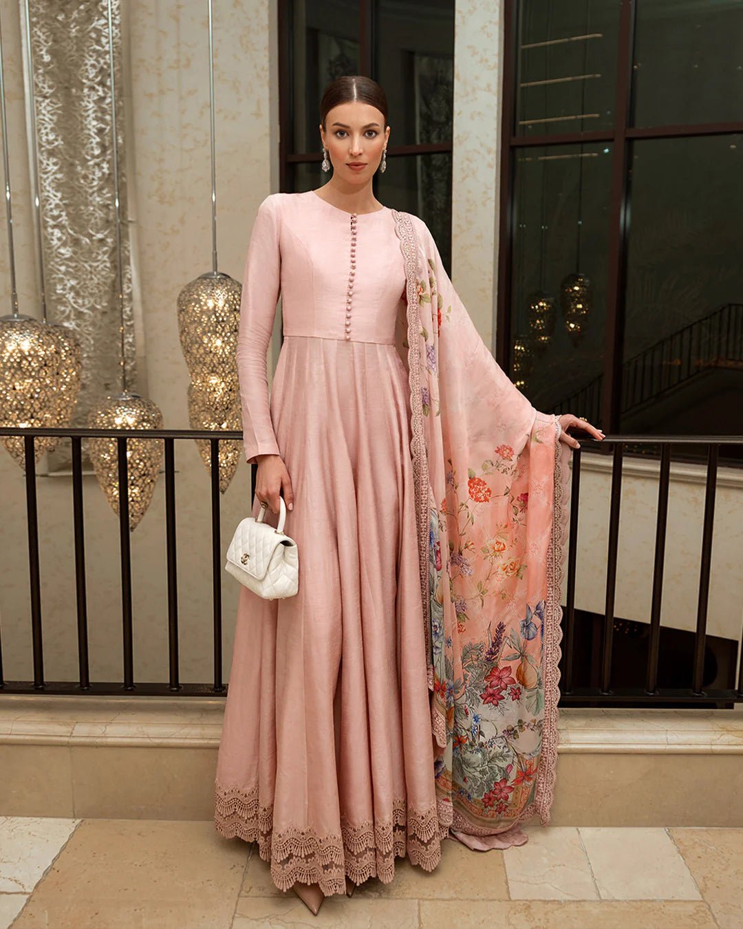 Model wearing the Zelina dress from Faiza Saqlain’s Zurina Luxe Silk Edit 2024, in blush pink with a floral dupatta. Pakistani designer clothes available in the UK. Ideal for Eid dresses.