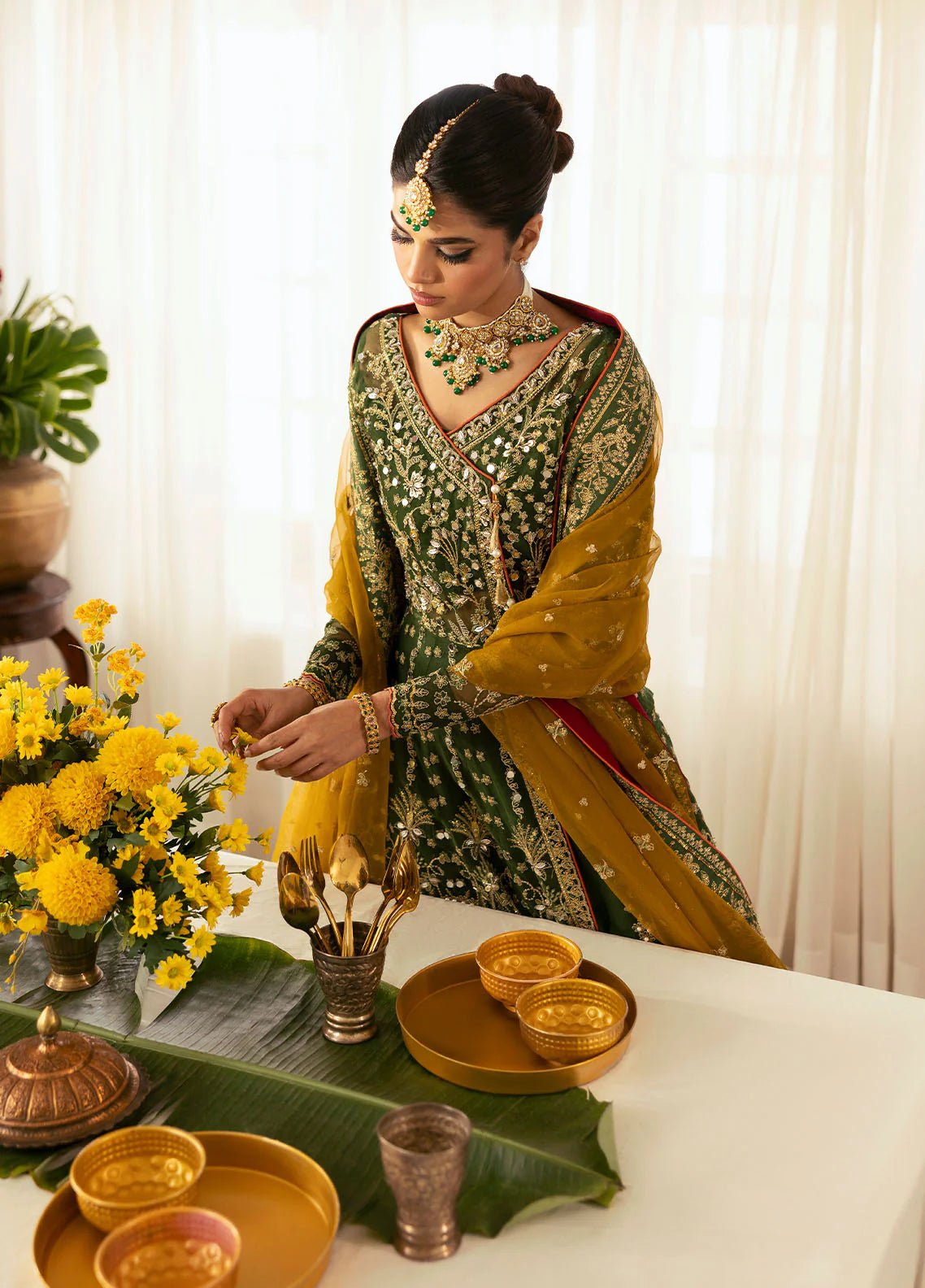 Model wearing Gulaal Maahru deep green and mustard embroidered wedding lehenga with intricate embellishments and contrasting dupatta. Shop Pakistani clothes online in the UK now.