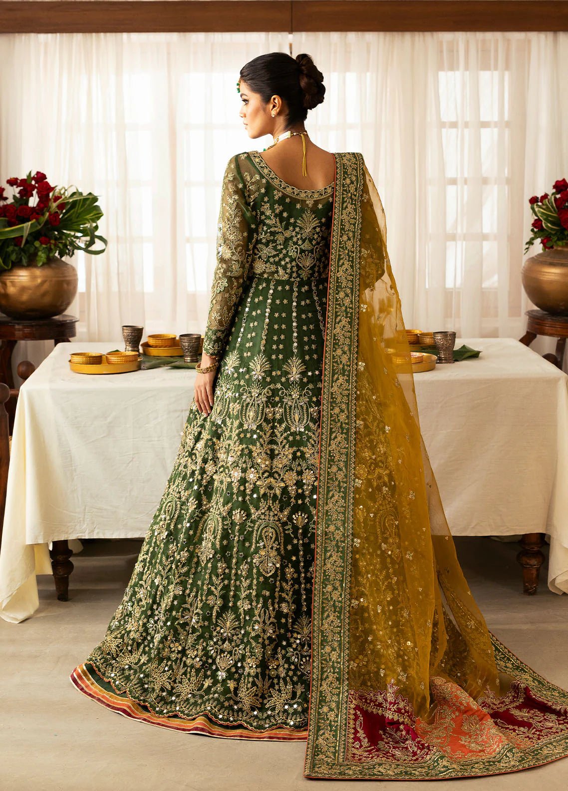 Model wearing Gulaal Maahru deep green and mustard embroidered wedding lehenga with intricate embellishments and contrasting dupatta. Shop Pakistani clothes online in the UK now.