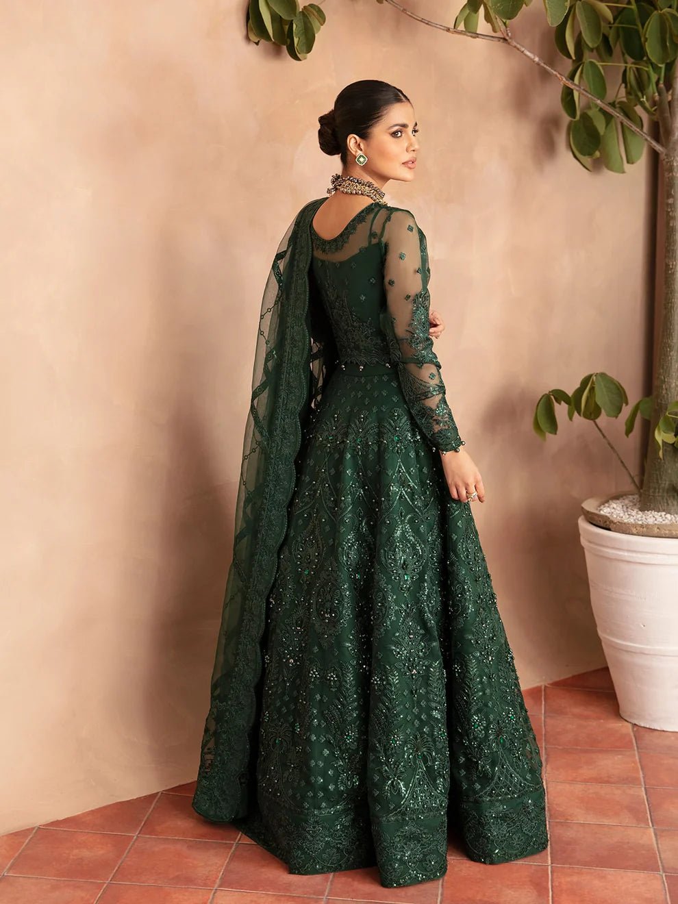 Model wearing a dark green AURORA GL - LP - V2 - 18 dress from Gulaal. Ideal for showcasing Pakistani clothes online in the UK. The dress features intricate embellishments, perfect for luxury pret collections.