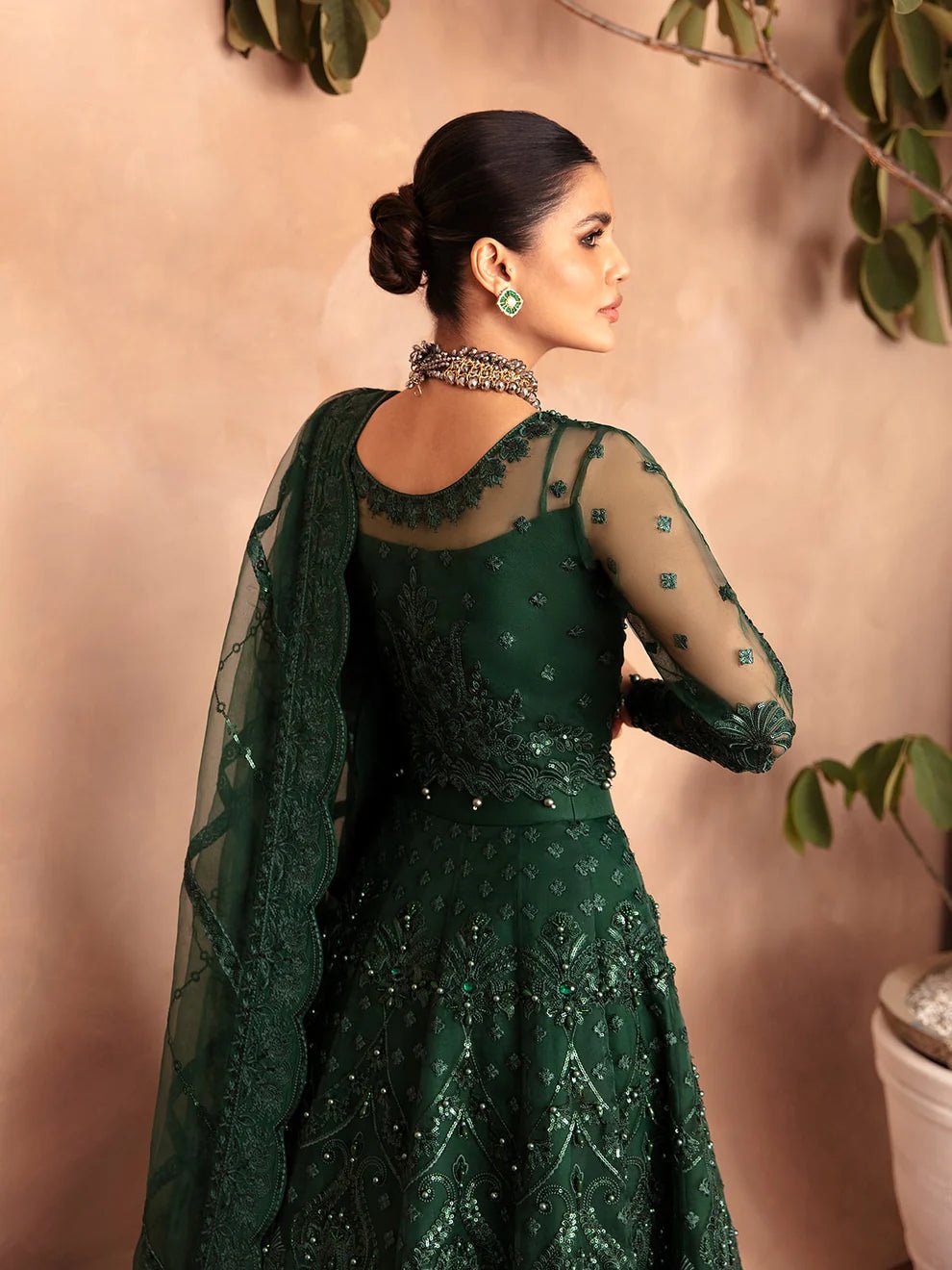 Model wearing a dark green AURORA GL - LP - V2 - 18 dress from Gulaal. Ideal for showcasing Pakistani clothes online in the UK. The dress features intricate embellishments, perfect for luxury pret collections.