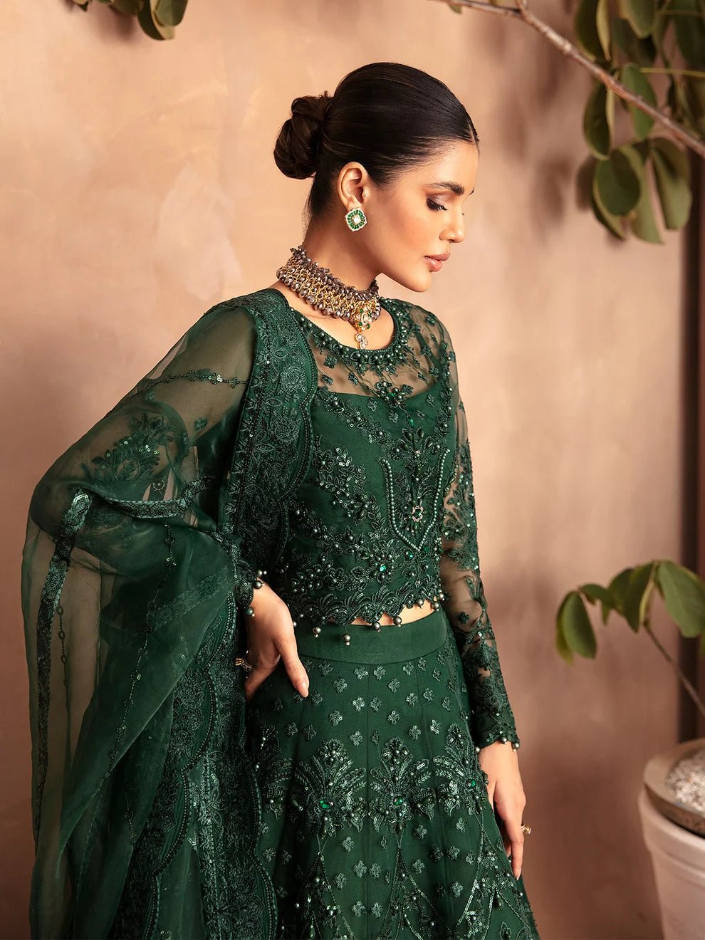 Model wearing a dark green AURORA GL - LP - V2 - 18 dress from Gulaal. Ideal for showcasing Pakistani clothes online in the UK. The dress features intricate embellishments, perfect for luxury pret collections.