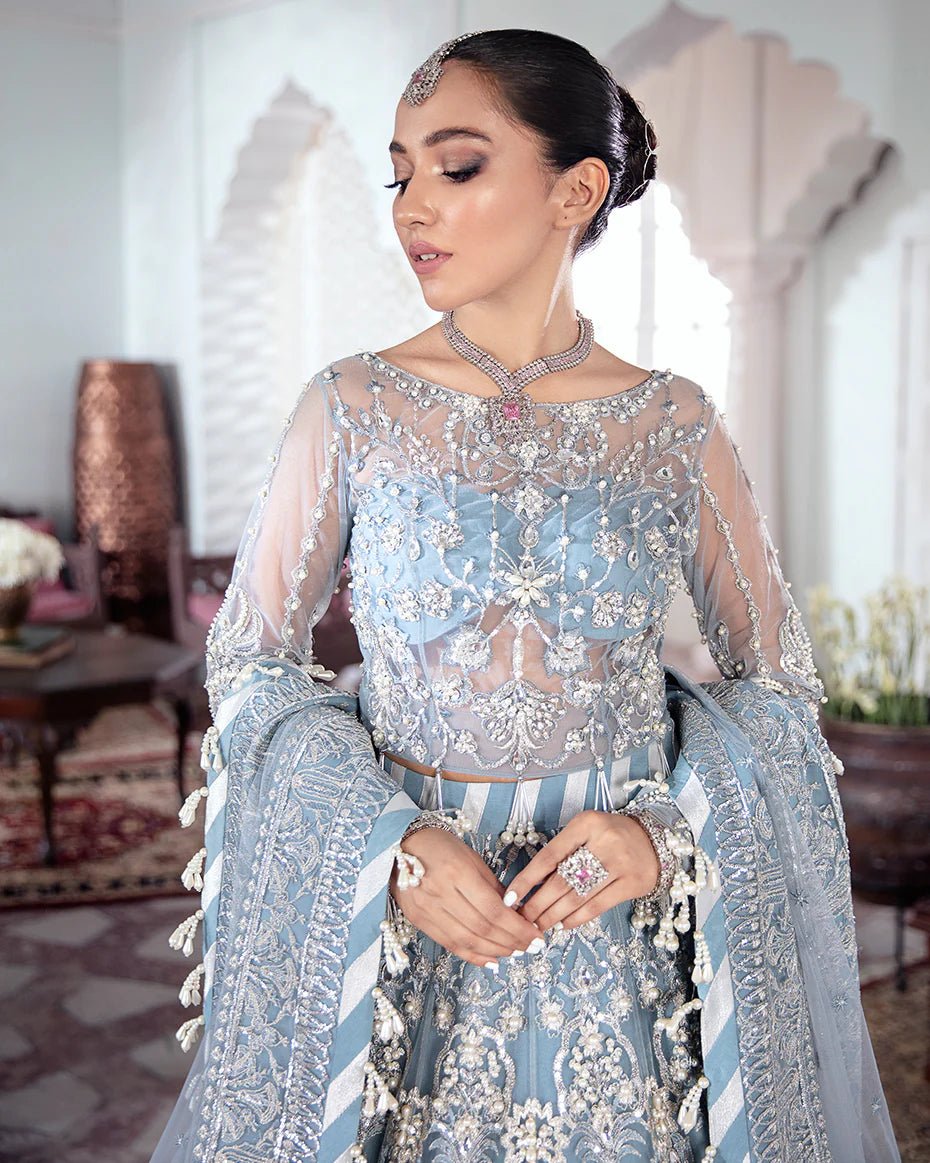 Model wearing a blue Mehnaaz Embroidered Net 3 - Piece Suit WS - 13 dress from Gulaal's Meherma Wedding Formals, showcasing Pakistani clothes online in the UK.