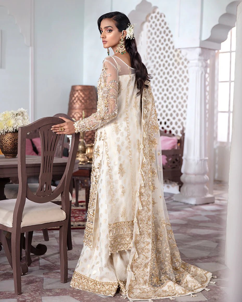 Model wearing an ivory Shehnaz Embroidered Net 3 - Piece Suit WS - 11 dress from Gulaal's Meherma Wedding Formals, showcasing Pakistani clothes online in the UK.