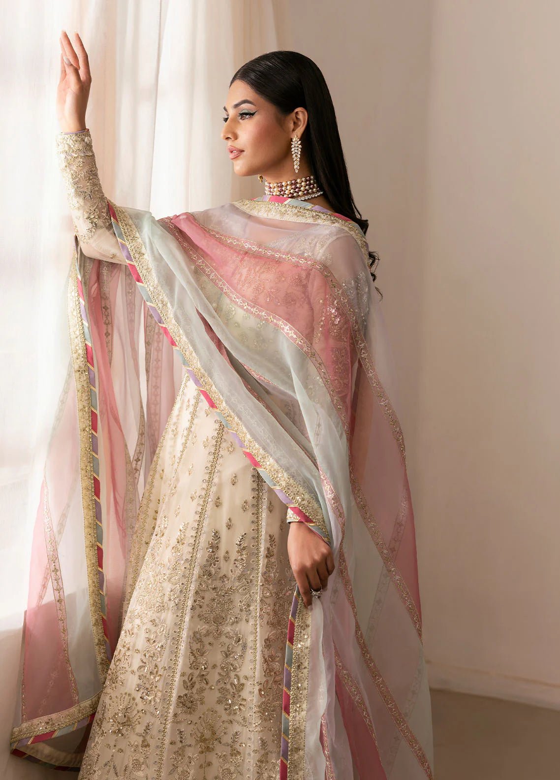 Model wearing Gulaal Chiragh ivory and pink embroidered chiffon dress with embellished dupatta. Shop Pakistani clothes online in the UK now.