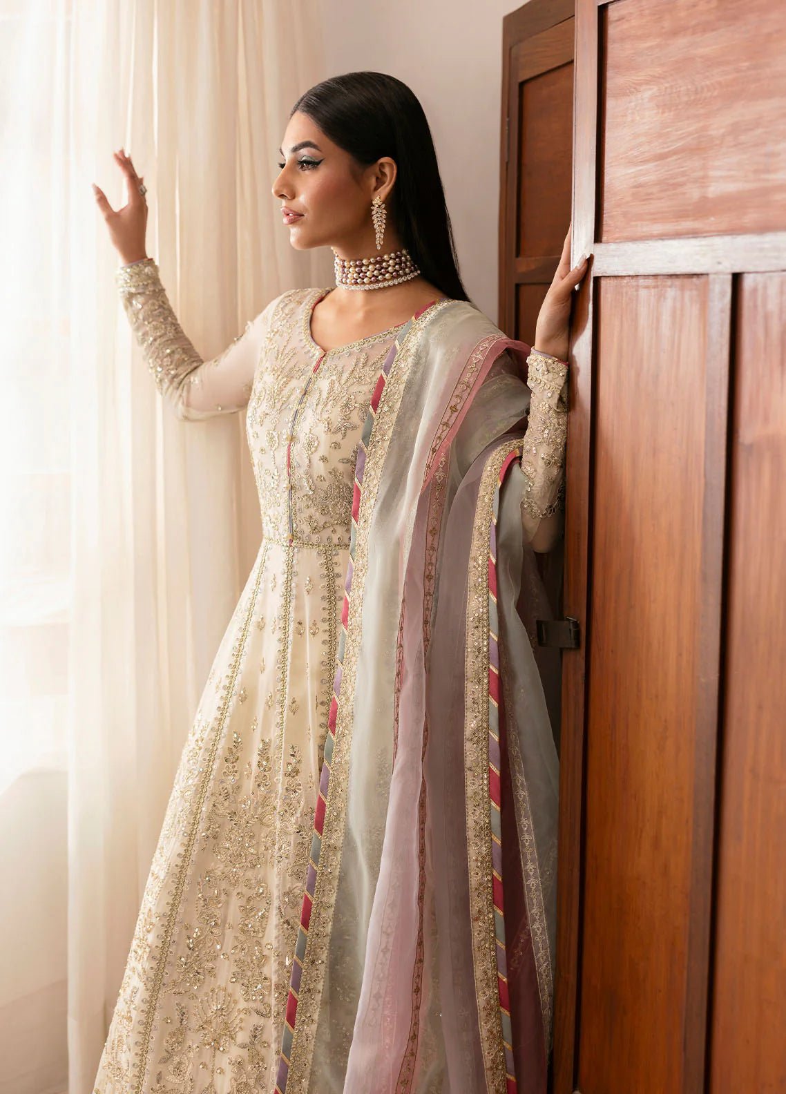 Model wearing Gulaal Chiragh ivory and pink embroidered chiffon dress with embellished dupatta. Shop Pakistani clothes online in the UK now.