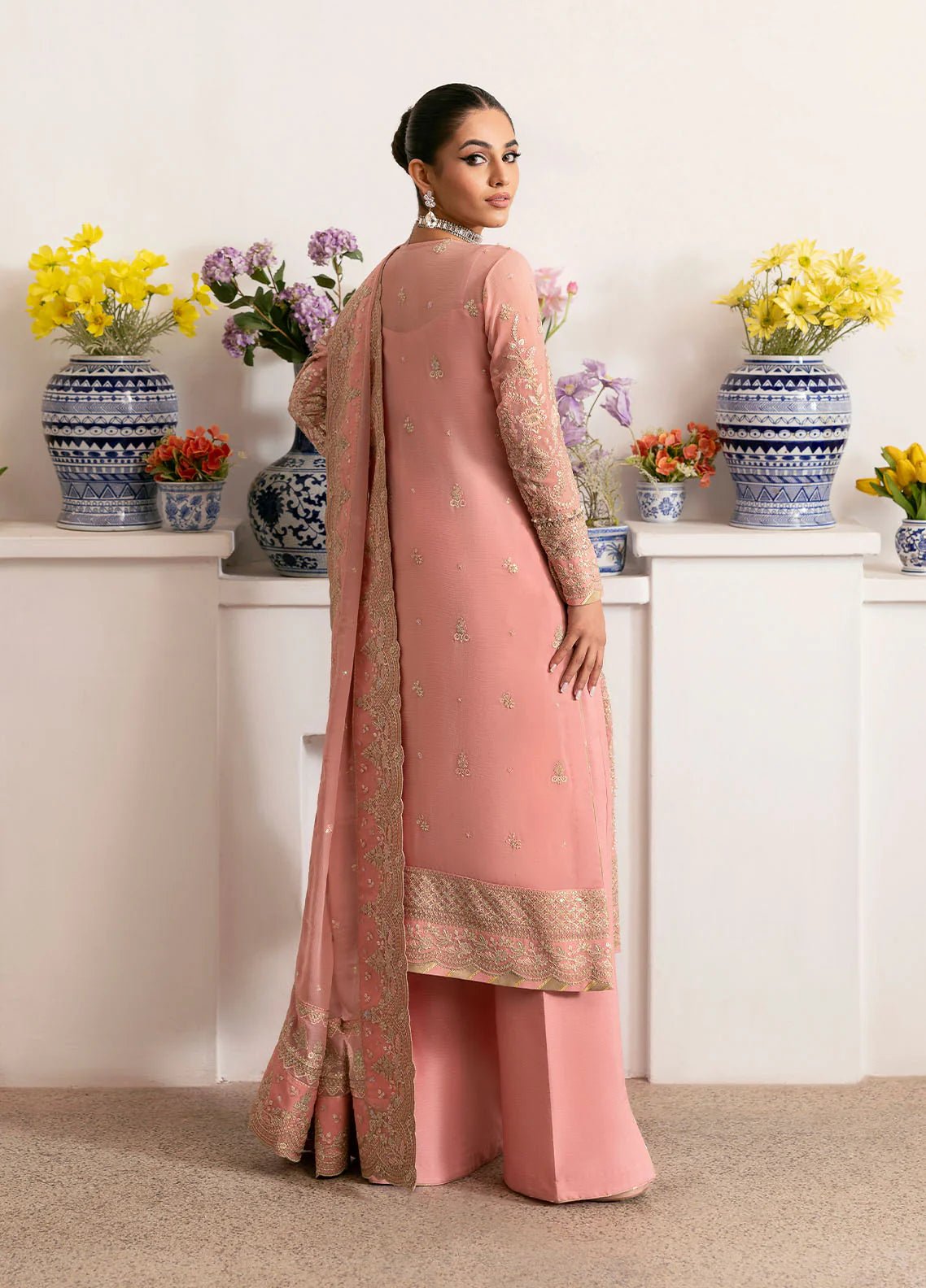 Model wearing Gulaal Coralyn blush pink embroidered chiffon dress with embellished dupatta. Shop Pakistani clothes online in the UK now.