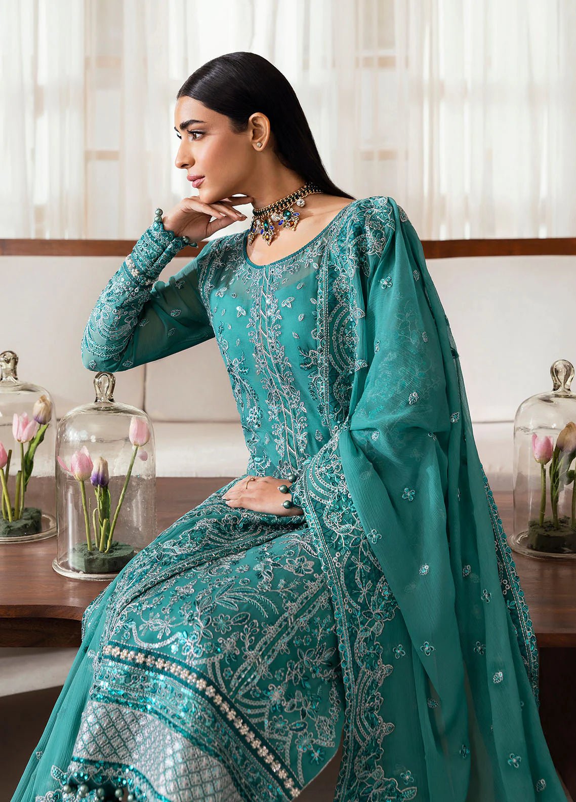 Model wearing Gulaal Miral teal embroidered chiffon dress with matching dupatta and trousers. Shop Pakistani clothes online in the UK now.