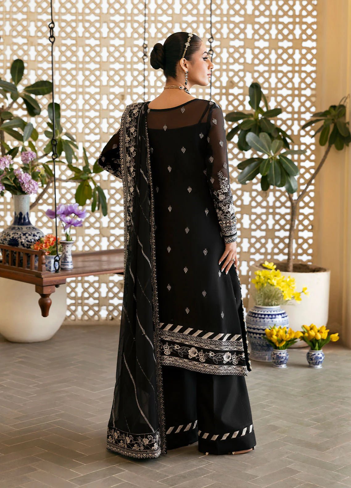 Model wearing Gulaal Nyra black embroidered chiffon dress with intricate silver detailing and dupatta. Shop Pakistani clothes online in the UK now.