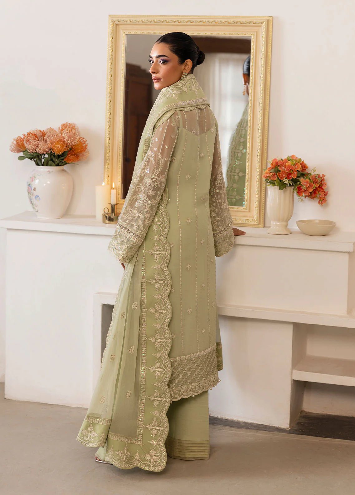 Model wearing Gulaal Virida pastel green embroidered chiffon dress with matching dupatta and trousers. Shop Pakistani clothes online in the UK now.