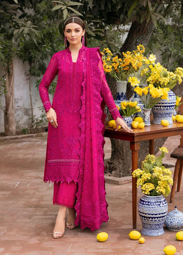 Model wearing Gulaal Zevira hot pink embroidered chiffon dress with matching dupatta and trousers. Shop Pakistani clothes online in the UK now.