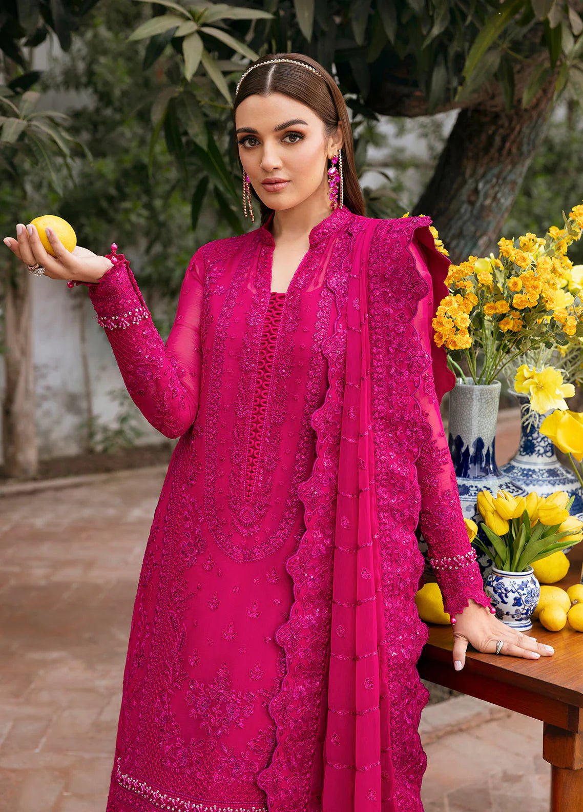 Model wearing Gulaal Zevira hot pink embroidered chiffon dress with matching dupatta and trousers. Shop Pakistani clothes online in the UK now.